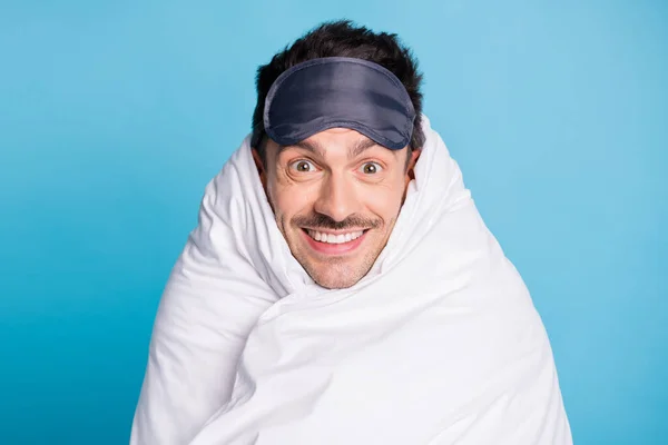 Portrait photo d'un homme positif souriant enveloppé dans une couette isolée sur un fond bleu vif — Photo
