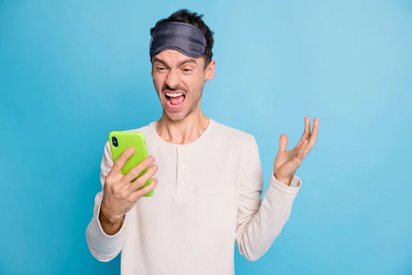Фотопортрет кричащего мужчины, держащего телефон в одной руке, изолированный на ярком синем фоне — стоковое фото