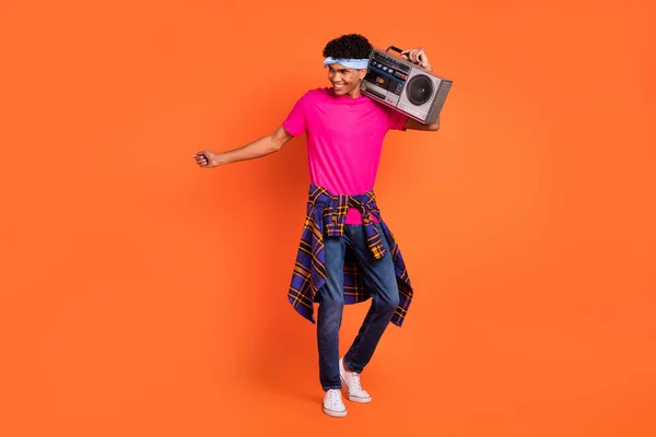 Tamanho total do corpo foto de jovem feliz mantendo boom-box ouvir música isolada no fundo cor de laranja vibrante — Fotografia de Stock