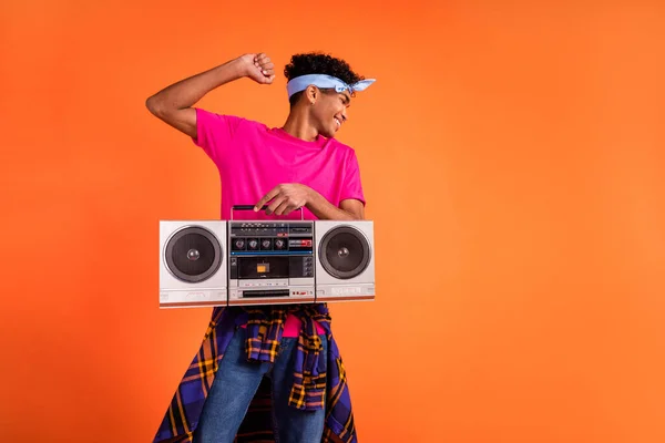 Foto de hipster chico hold boombox dance wear rosa camiseta a cuadros camisa anudada diadema aislado fondo naranja —  Fotos de Stock