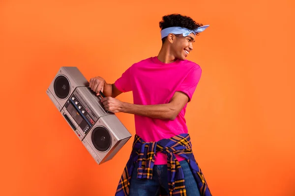 Retrato fotográfico de un joven hipster bailando riendo sosteniendo la grabadora en una fiesta aislada en un vibrante espacio de copia de fondo de color naranja —  Fotos de Stock