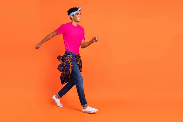 Longitud completa tamaño del cuerpo foto joven sonriendo paso usando ropa de moda aislado color naranja brillante fondo — Foto de Stock