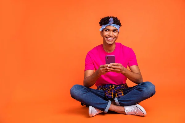 Full length body size photo of curious dreamy hipster reading news with mobile phone isolated vivid orange color background copyspace — Zdjęcie stockowe