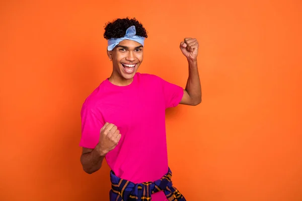 Foto porträtt av leende kille med piercing gest som vinnare isolerad levande orange färg bakgrund — Stockfoto