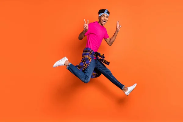 Volledige grootte foto van jonge knappe funky positieve afro man springen tonen v-teken geïsoleerd op oranje kleur achtergrond — Stockfoto