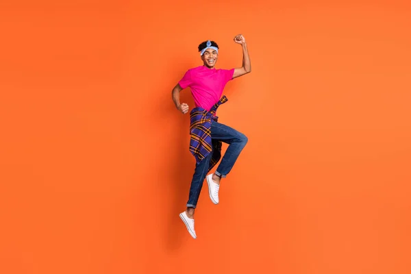 Volledige lengte lichaam grootte zijkant profiel foto van man springen hoog gebaar als winnaar geïsoleerde levendige oranje kleur achtergrond — Stockfoto