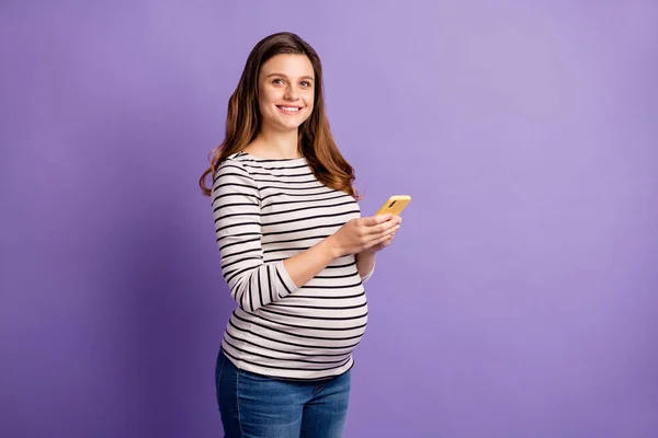 Foto da senhora grávida segurar telefone olhar câmera desgaste camisa listrada isolado cor violeta fundo — Fotografia de Stock