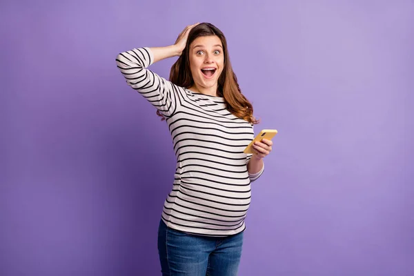 Foto de señora emocionada esperando bebé vestido camisa rayada ombligo brazo cabeza sosteniendo gadget moderno aislado color violeta fondo — Foto de Stock