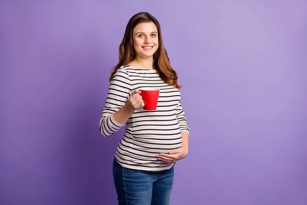Foto van zwangere dame houden mok drinken thee hand buik dragen gestreept shirt geïsoleerde violette kleur achtergrond — Stockfoto
