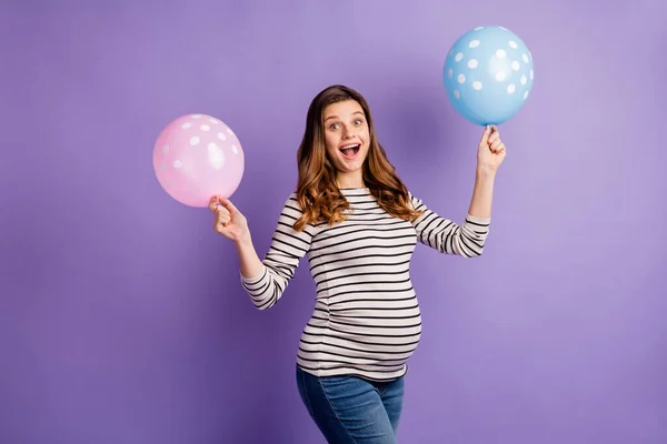 Foto portrét těhotné vzrušené dívky drží růžové a modré balónky izolované na živé fialové barevné pozadí — Stock fotografie