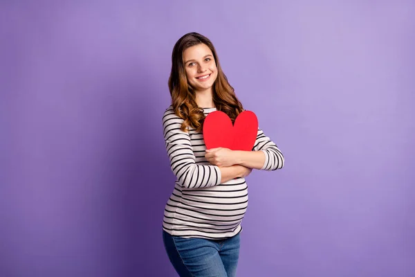 Foto retrato de menina grávida abraçando grande cartão de coração vermelho isolado no fundo colorido violeta vívido — Fotografia de Stock