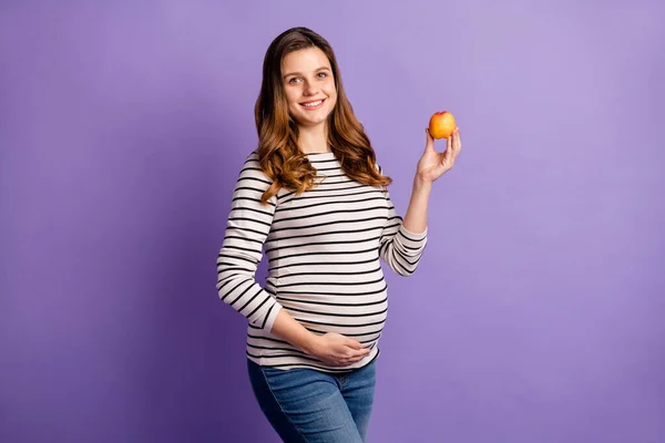 Foto portret van zwangere vrouw met appel geïsoleerd op levendige violette gekleurde achtergrond — Stockfoto