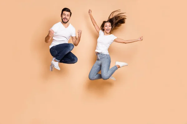 Full body photo of young excited couple happy positive smile active jump up usure denim isolé sur fond de couleur beige — Photo