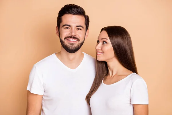 Fotografie okouzlující sladký manžel manželka nosit bílé trička objímání s úsměvem izolované béžové barvy pozadí — Stock fotografie