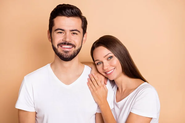 Foto de encantador casal muito casado vestido t-shirts brancas com descanso ombro isolado cor bege fundo — Fotografia de Stock