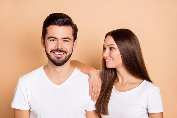 Photo of cute adorable husband wife wear white t-shirts smiling arm shoulder isolated beige color background — Stock Photo, Image