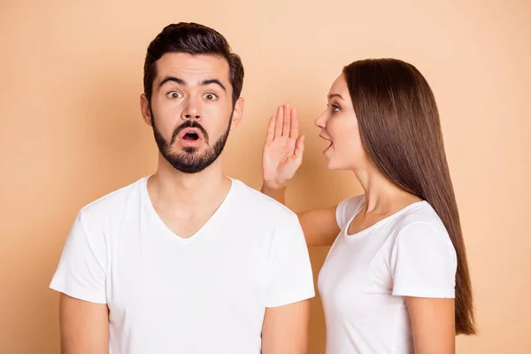 Photo of young girl tell say her amazed shocked surprised boyfriend secret gossip isolated over beige color background — Stock Photo, Image