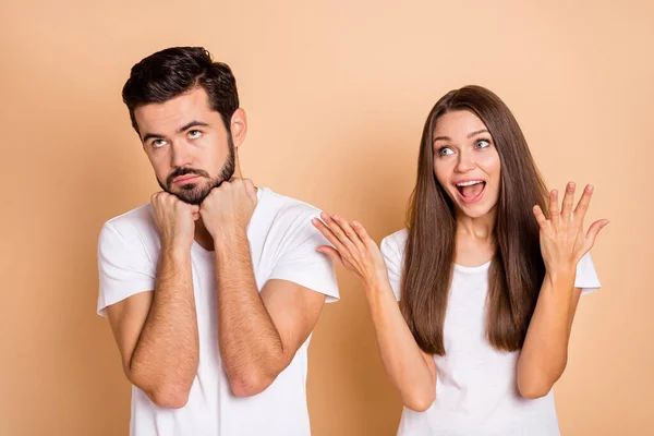 Foto von gestressten Streit Ehepaar gekleidet weißes T-Shirt suchen leeren Raum ansteigende Arme isoliert beige Farbe Hintergrund — Stockfoto
