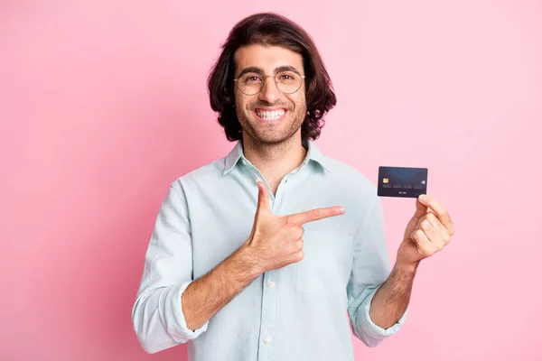 Foto van optimistisch mooi bruin haar man punt kaart dragen bril blauw shirt geïsoleerd op pastel roze kleur achtergrond — Stockfoto