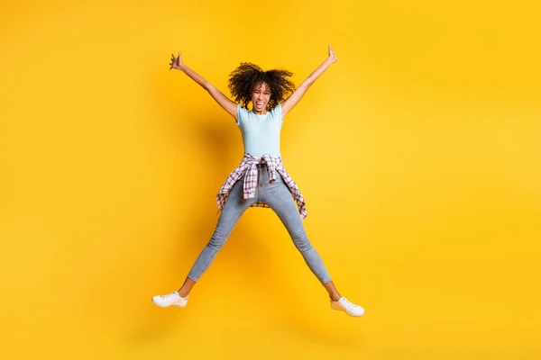 Foto de longitud completa de adorable linda piel oscura dama ondulada desgaste azul camiseta salto estrella aislado color amarillo fondo — Foto de Stock