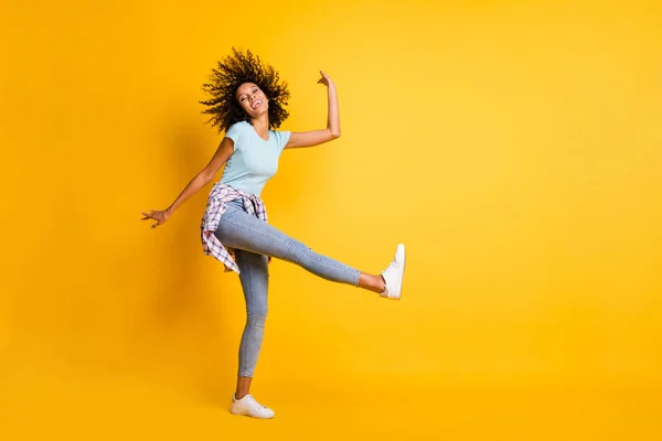 Foto de engraçado brilhante pele escura ondulado senhora desgaste azul t-shirt dança vazio espaço isolado cor amarela fundo — Fotografia de Stock