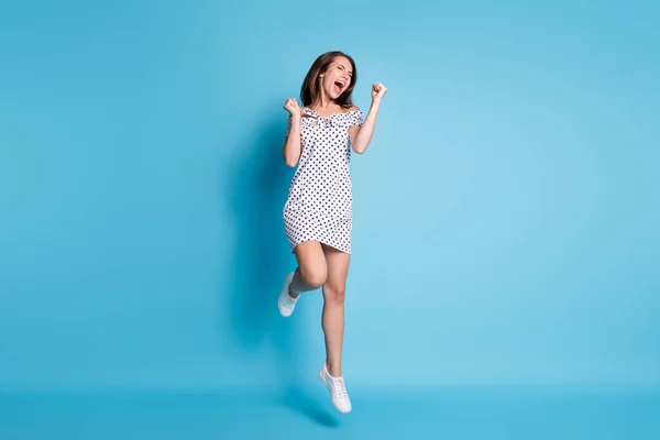 Полная длина фото леди прыгать удивленное лицо закрытые глаза носить пунктирные короткие кроссовки платье изолированный синий цвет фона — стоковое фото