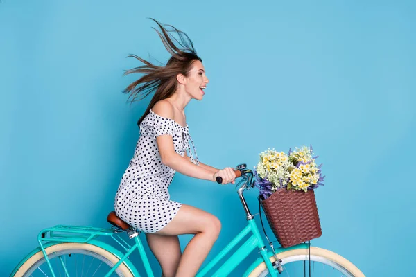 Funk kız sürüş bisikletinin tam boy profil fotoğrafı boş görünüyor açık ağız giysisi noktalı kısa elbise izole edilmiş mavi arka plan — Stok fotoğraf