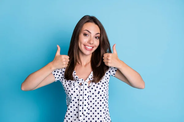 Foto von aufgeregten hübschen Mädchen heben zwei Hände zeigen Daumen nach oben tragen gepunktete Bluse isoliert blaue Farbe Hintergrund — Stockfoto