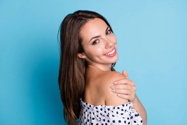 Photo of inspired pretty young girl embrace shoulders look camera wear dotted blouse isolated blue color background — Stock Photo, Image