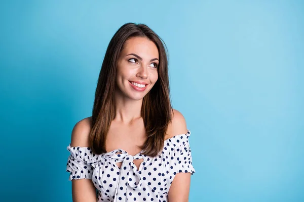 Foto di bella ragazza sorriso lucido guardare spazio vuoto indossare camicetta punteggiata isolato colore blu sfondo — Foto Stock