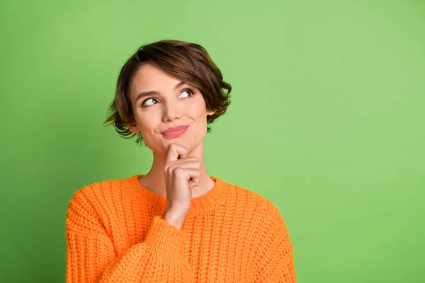 Portret optymistycznej ładnej brunetki wyglądać puste miejsce nosić pomarańczowy sweter odizolowany na pastelowym zielonym tle — Zdjęcie stockowe
