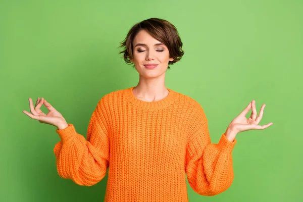Портрет оптимистической брюнетки дамы скрещенные пальцы носить оранжевый свитер изолированы на пастельно-зеленом фоне — стоковое фото