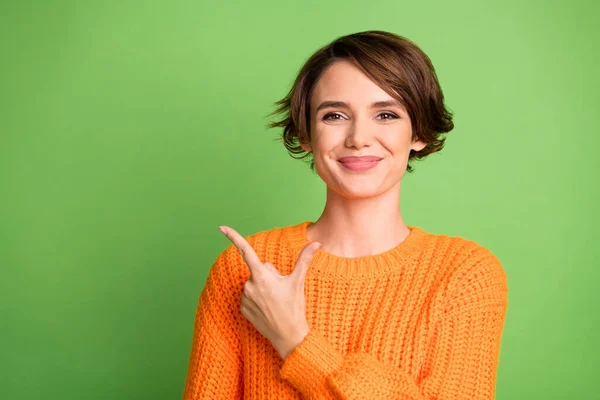 Фото позитивної щасливої молодої жінки вказують пальцем порожній простір зворотного зв'язку промоутер ізольований на зеленому кольоровому фоні — стокове фото