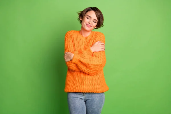 Foto de joven soñadora positiva mujer relajada abrazarse relajar los ojos cerrados aislados sobre fondo de color verde — Foto de Stock