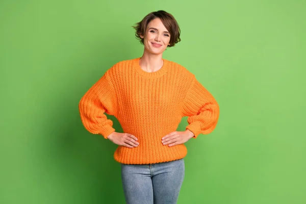 Foto de atraente alegre jovem mulher segurar as mãos cintura desgaste casual roupa isolada no fundo de cor verde — Fotografia de Stock