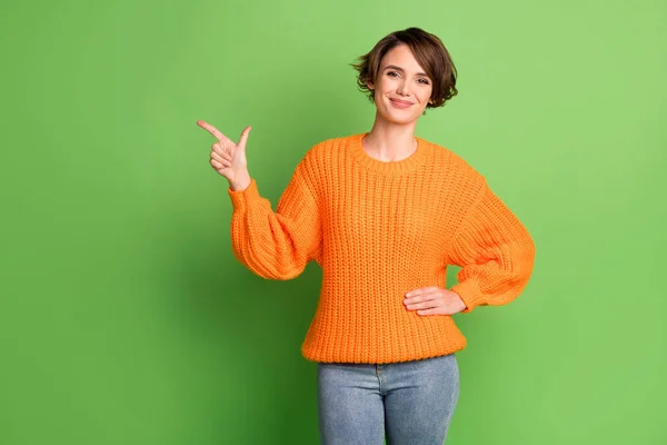 Fénykép a vonzó pozitív hölgy mutatóujj üres tér tartsa a kezét elszigetelt zöld színű háttér — Stock Fotó