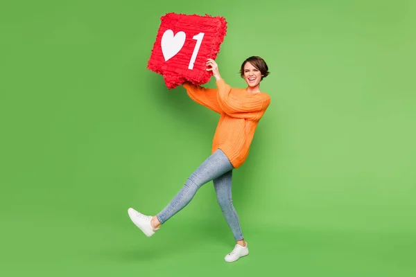 Foto em tamanho completo de feliz alegre jovem mulher vencedora conseguir como segurar grande ícone notificação isolado no fundo de cor verde — Fotografia de Stock