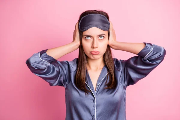 Foto retrato de chica cansada cubriendo orejas con dos manos aisladas sobre fondo de color rosa pastel — Foto de Stock