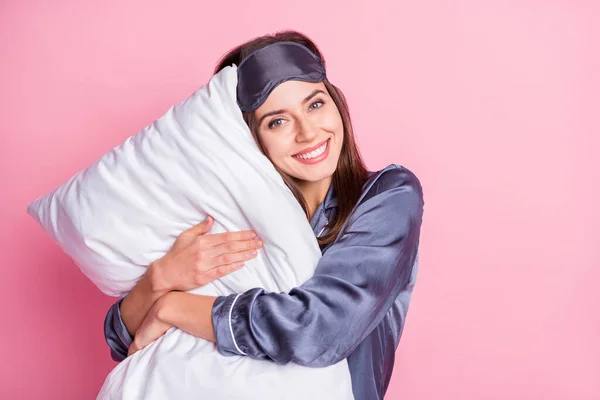 照片中可爱的女孩抱着枕头，与粉红的背景相隔离 — 图库照片