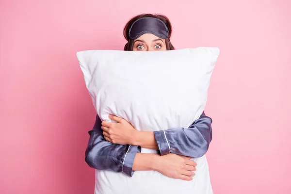 Foto retrato de niña abrazando almohada escondida aislada sobre fondo de color rosa pastel — Foto de Stock