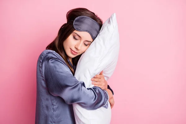 Portret spokojnej dziewczyny śpiącej przytulając poduszkę dwiema rękami na pastelowym różowym tle — Zdjęcie stockowe