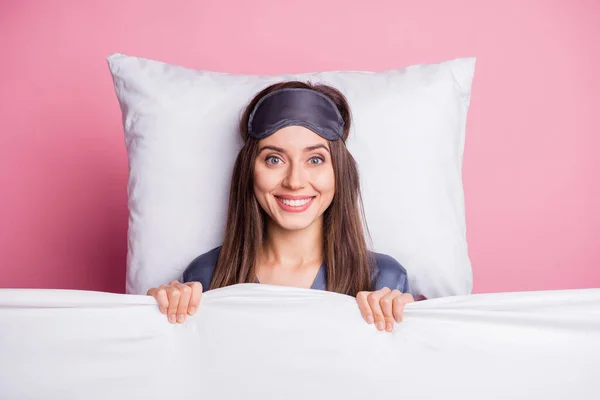 Φωτογραφία πορτρέτο του όμορφη μελαχρινή φορώντας νυχτικά ψύξη που βρίσκεται κάτω από κουβέρτα στο κρεβάτι απομονώνονται σε παστέλ ροζ χρώμα φόντο — Φωτογραφία Αρχείου