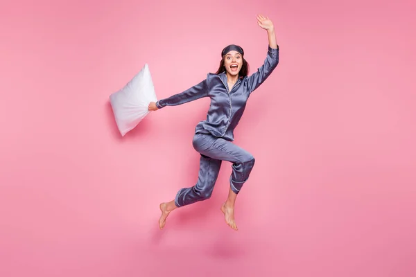 Foto de tamaño completo del cuerpo de la niña que usa pijama agitando la mano con almohada en la mañana tarde aislado sobre fondo de color rosa pastel — Foto de Stock