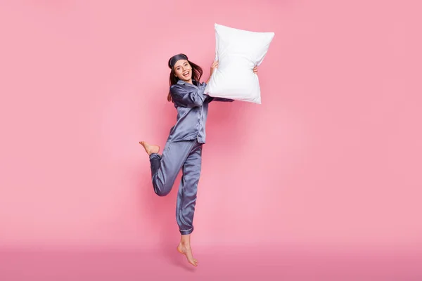 Volledige lichaamslengte foto van meisje in slaapkledij lachen vechten met kussen op pyjama partij geïsoleerd op pastel roze kleur achtergrond — Stockfoto