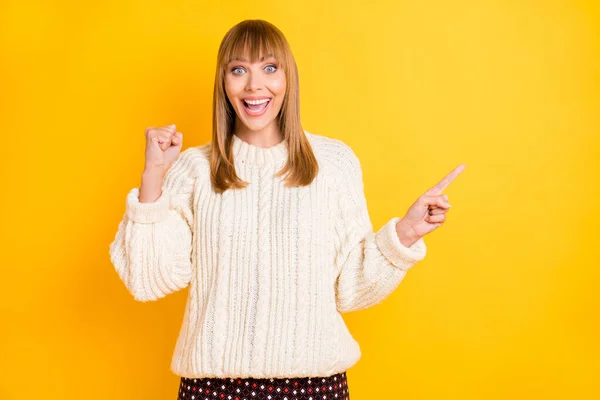 Photo of delighted person fist up indicate finger empty space wear knitted style sweater isolated on yellow color background — Stock Photo, Image