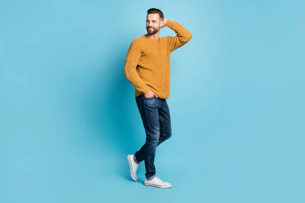 Full storlek foto av unga stilig attraktiv leende man ser copyspace bära jeans isolerade på blå färg bakgrund — Stockfoto