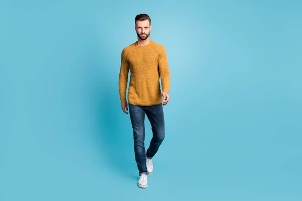 Foto em tamanho completo de jovem bonito confiante homem legal ir andar usar camisola de malha amarela isolada no fundo de cor azul — Fotografia de Stock