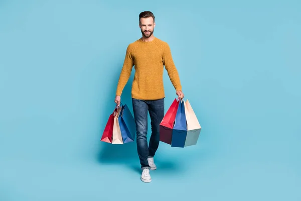 Foto de tamaño completo de joven sonriente positivo hombre guapo alegre ir a caminar después de comprar aislado en el fondo de color azul — Foto de Stock