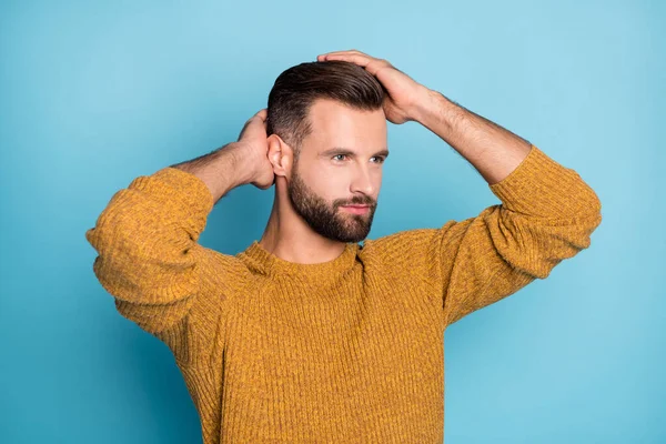Fénykép a fiatal jóképű pozitív jóképű férfi néz copyspace rögzítő frizura elszigetelt kék színű háttér — Stock Fotó
