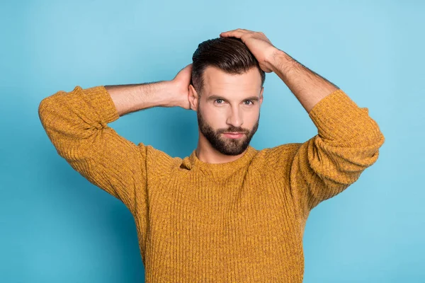 Foto de joven confiado serio guapo hombre fresco fijación de peinado desgaste suéter de punto amarillo aislado sobre fondo de color azul — Foto de Stock